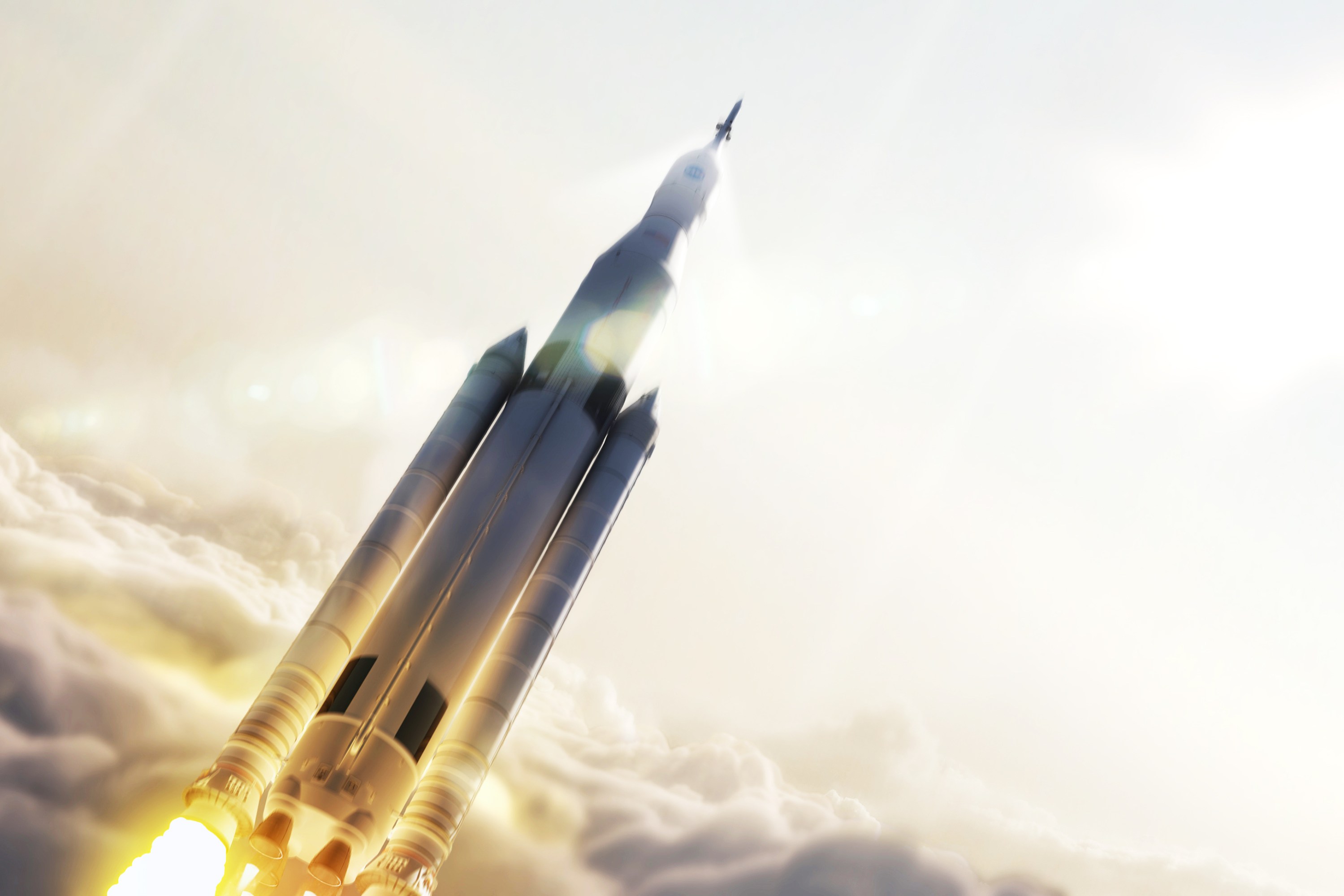 Rocket launching through cloudy sky with bright exhaust flames.