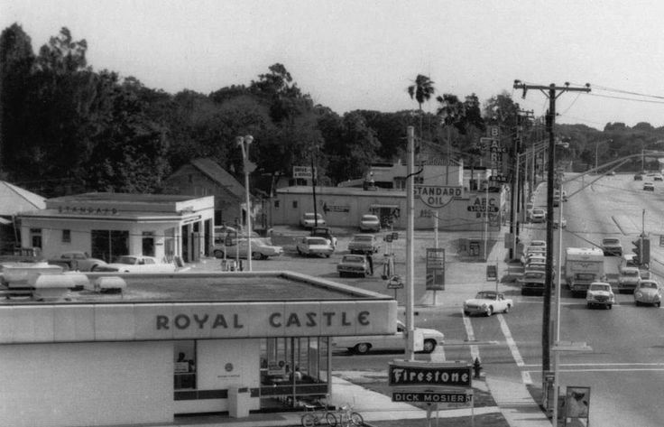 Black and white image of a vintage street with Royal Castle and Standard Oil signs.