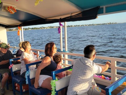 Passengers enjoy a boat ride on a sunny day, admiring the water view.