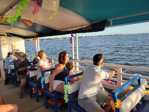 People on a decorated boat enjoying a sunny day on the water.