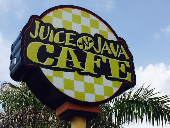 Sign for 'Juice-N-Java Cafe' with checkered background next to palm trees.