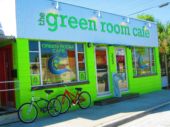 Bright green café exterior with 'Green Room Cafe' sign and two bicycles parked outside.