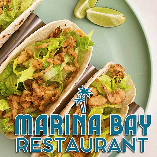 Tacos with lettuce and chicken on a plate, lime wedges, text: Marina Bay Restaurant.