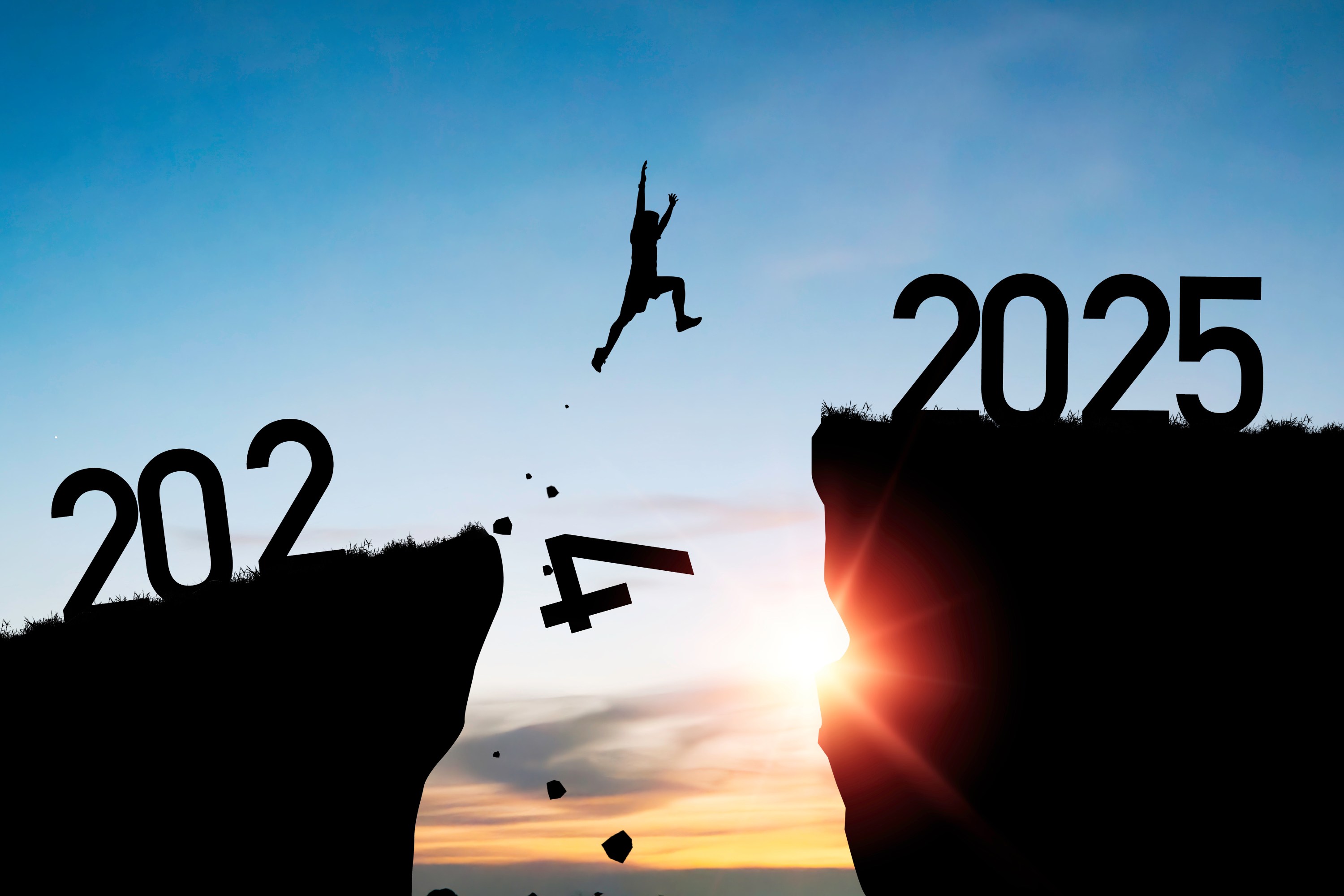 Silhouette of person jumping from 2024 to 2025, symbolizing transition to the new year.