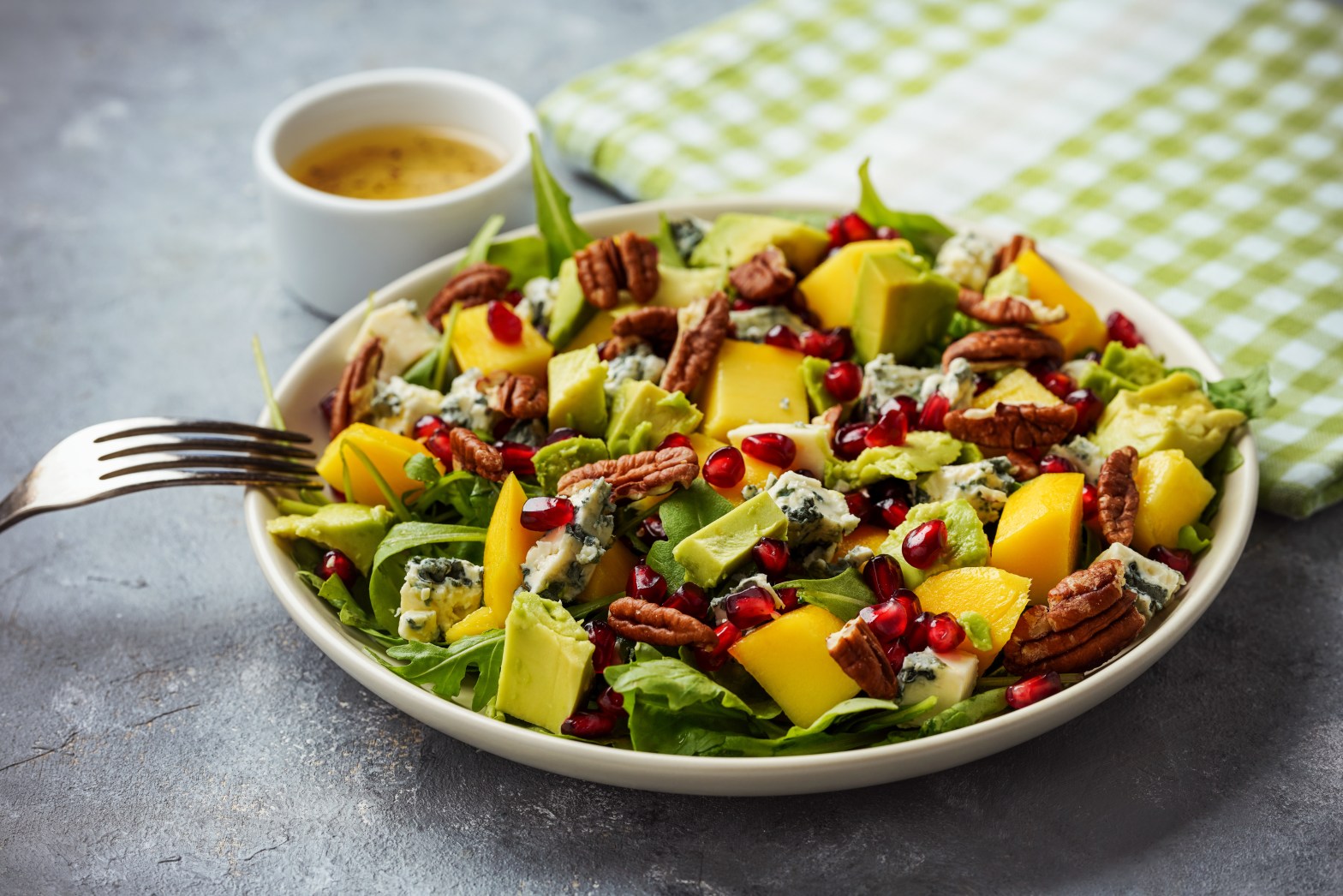 Salad with mango, avocado, pecans, pomegranate, and cheese.